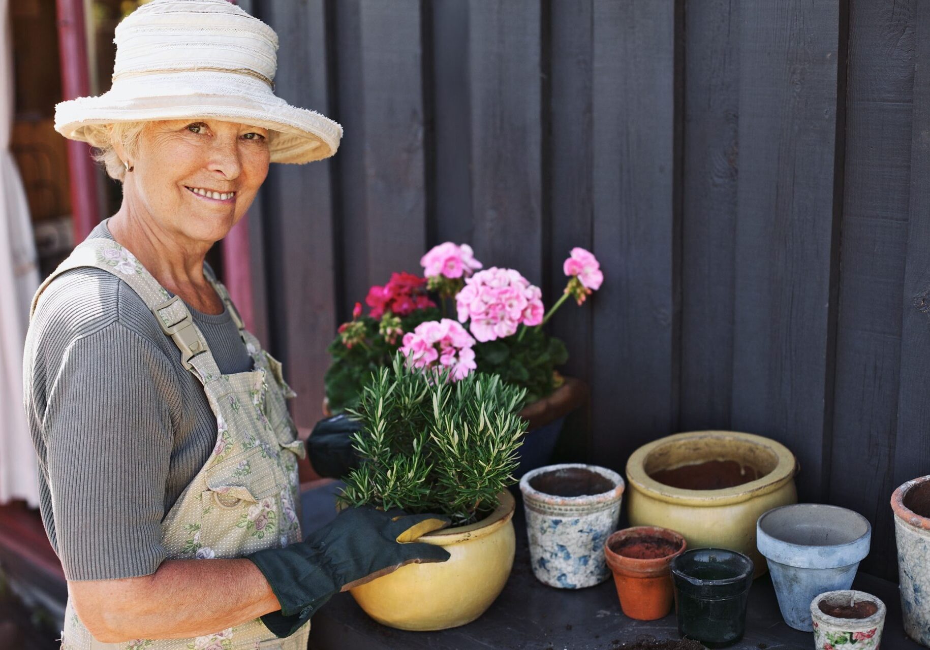 A woman in an apron and hat is holding flowers.